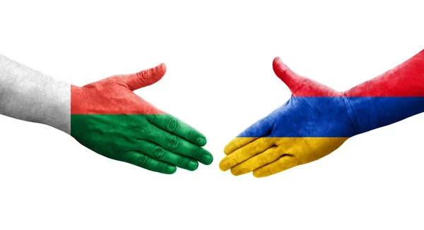 stock image Handshake between Armenia and Madagascar flags painted on hands, isolated transparent image.