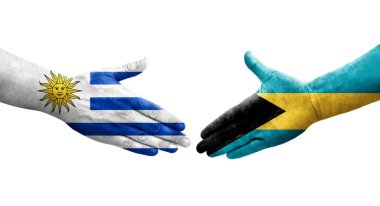 Bahamalar ve Uruguay bayrakları arasındaki el sıkışma ellerinde izole şeffaf görüntü.