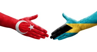 Ellere boyanmış Bahamalar ve Türkiye bayrakları arasındaki el sıkışma, izole edilmiş şeffaf görüntü.