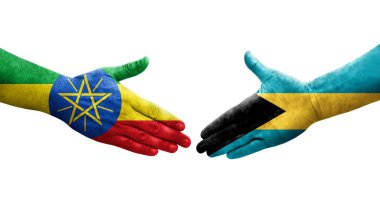 Bahamalar ve Etiyopya bayrakları arasındaki el sıkışma ellerinde izole şeffaf görüntü.