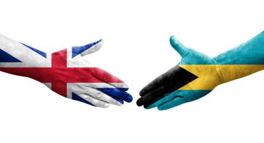 Bahamalar ve Büyük Britanya bayrakları arasındaki el sıkışma ellerinde resmedilmiş şeffaf bir görüntü.