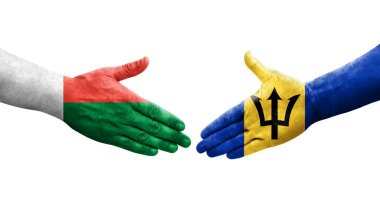 Barbados ve Madagaskar bayrakları arasındaki tokalaşma elleri boyalı, izole şeffaf görüntü.