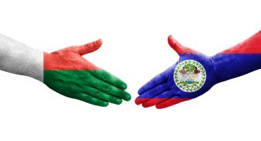 Belize ve Madagaskar bayrakları arasındaki tokalaşma elleri boyalı, izole saydam görüntü.