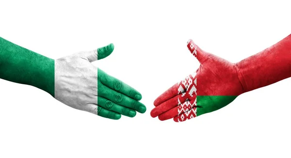 手に描かれたベラルーシとナイジェリアの旗の間の握手 孤立した透明なイメージ — ストック写真