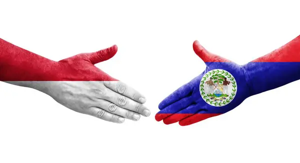 stock image Handshake between Belize and Monaco flags painted on hands, isolated transparent image.