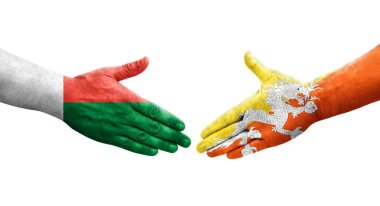 Bhutan ve Madagaskar bayrakları arasındaki tokalaşma elleri boyalı, izole şeffaf görüntü.