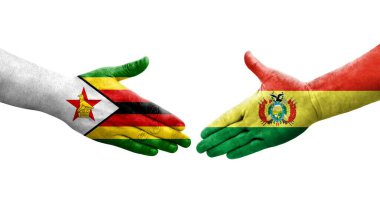 Bolivya ve Zimbabwe bayrakları arasındaki el sıkışma ellerinde izole şeffaf görüntü.