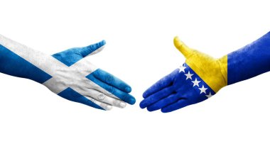 Bosna ve İskoçya bayrakları arasındaki el sıkışma ellerinde resmedilmiş şeffaf bir görüntü.