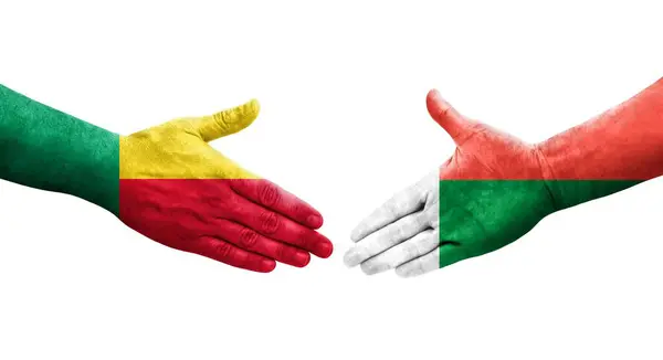 stock image Handshake between Benin and Madagascar flags painted on hands, isolated transparent image.