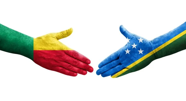 stock image Handshake between Benin and Solomon Islands flags painted on hands, isolated transparent image.