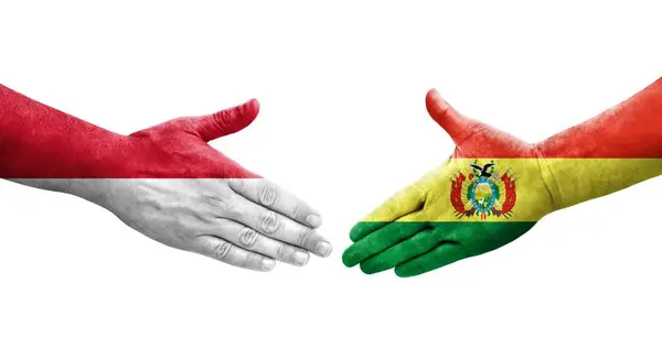 stock image Handshake between Bolivia and Monaco flags painted on hands, isolated transparent image.