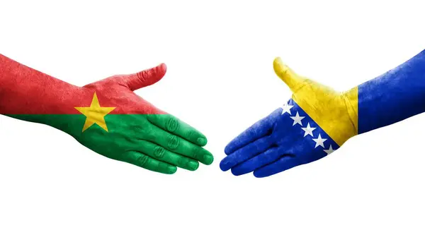 stock image Handshake between Bosnia and Burkina Faso flags painted on hands, isolated transparent image.