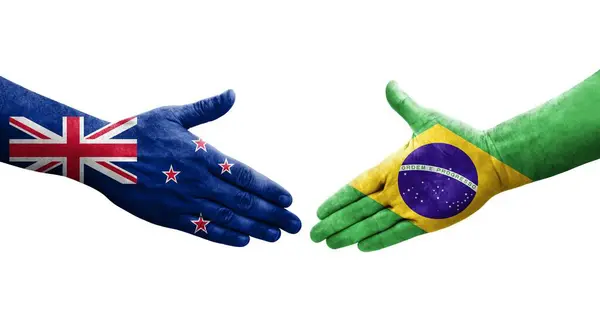 手に描かれたブラジルとニュージーランドの旗の間の握手 孤立した透明なイメージ — ストック写真