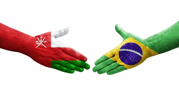 手に描かれたブラジルとオマーンの旗の間の握手 隔離された透明なイメージ — ストック写真