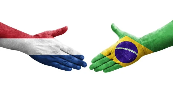 手に描かれたブラジルとオランダの旗の間の握手 孤立した透明なイメージ — ストック写真