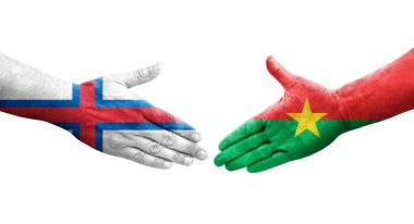 Burkina Faso ve Faroe Adaları arasındaki el sıkışma ellerinde boyanmış bayraklar, izole şeffaf görüntü.