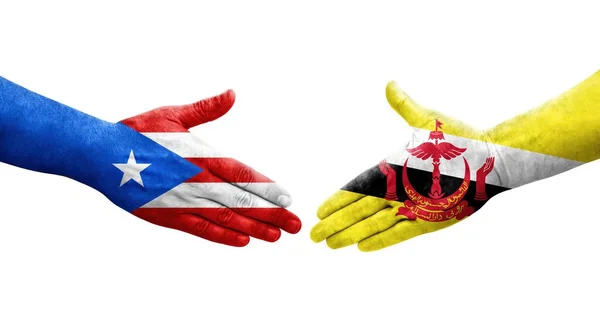 stock image Handshake between Brunei and Puerto Rico flags painted on hands, isolated transparent image.