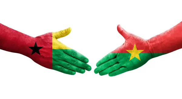 stock image Handshake between Burkina Faso and Guinea Bissau flags painted on hands, isolated transparent image.