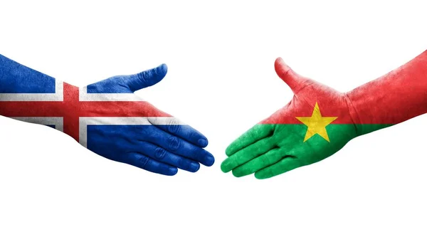 Stock image Handshake between Burkina Faso and Iceland flags painted on hands, isolated transparent image.