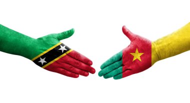 Kamerun ve Saint Kitts ve Nevis bayrakları arasındaki el sıkışma ellerinde izole şeffaf görüntü.