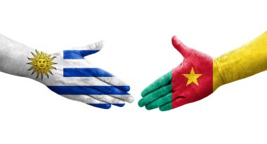 Kamerun ve Uruguay bayrakları arasındaki el sıkışma ellerinde izole şeffaf görüntü.