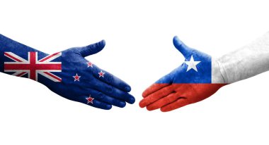 Ellere boyanmış Şili ve Yeni Zelanda bayrakları arasındaki el sıkışma, izole şeffaf görüntü.