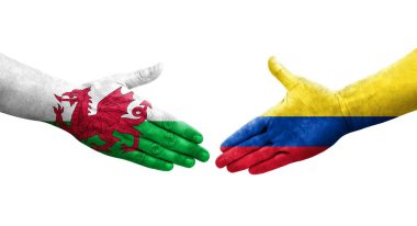 Kolombiya ve Galler arasındaki el sıkışma ellerinde boyanmış bayraklar, yalıtılmış şeffaf görüntü.