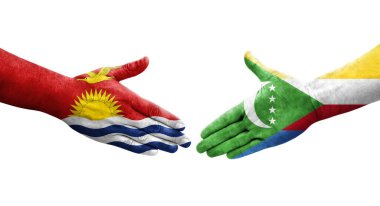 Ellerinde Comoros ve Kiribati bayrakları arasında el sıkışma, izole şeffaf görüntü.