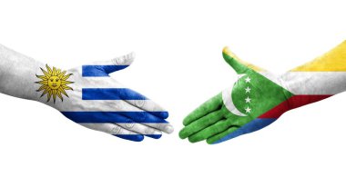 Comoros ve Uruguay bayrakları arasındaki el sıkışma ellerinde izole şeffaf görüntü.
