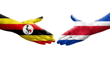 Ellerinde Kosta Rika ve Uganda bayrakları arasında el sıkışma, izole şeffaf görüntü.