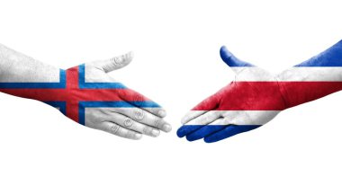 Ellerinde Kosta Rika ve Faroe Adaları bayrakları arasında el sıkışma, izole şeffaf görüntü.