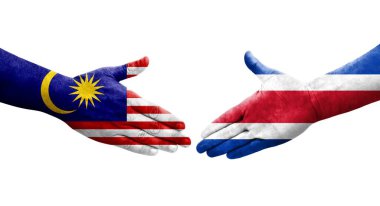 Ellerinde Kosta Rika ve Malezya bayrakları arasında el sıkışma, izole şeffaf görüntü.
