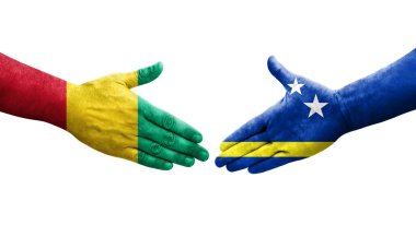 Curacao ve Gine bayrakları arasındaki tokalaşma elleri boyalı, izole şeffaf görüntü.