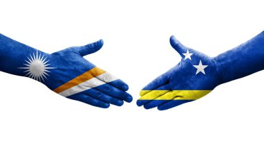 Curacao ve Marshall Adaları arasındaki el sıkışma ellerinde boyanmış bayraklar, izole şeffaf görüntü.