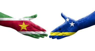 Curacao ve Surinam bayrakları arasındaki tokalaşma elleri boyalı, izole şeffaf görüntü.