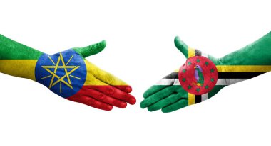 Dominika ve Etiyopya bayrakları arasındaki el sıkışma ellerinde boyanmış, izole şeffaf görüntü.