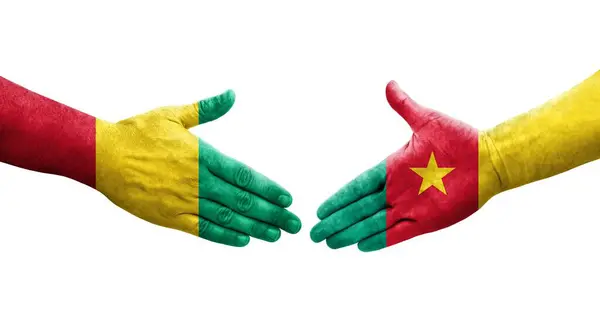 stock image Handshake between Cameroon and Guinea flags painted on hands, isolated transparent image.