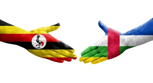 stock image Handshake between Central African Republic and Uganda flags painted on hands, isolated transparent image.