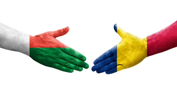 stock image Handshake between Chad and Madagascar flags painted on hands, isolated transparent image.