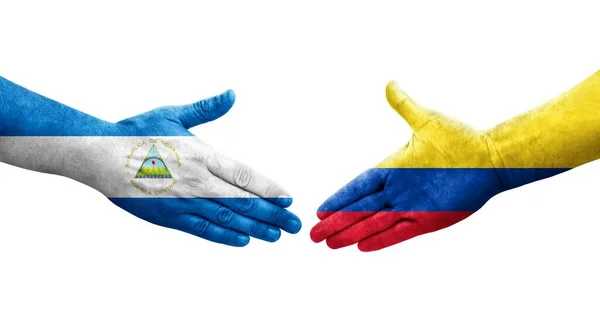 stock image Handshake between Colombia and Nicaragua flags painted on hands, isolated transparent image.