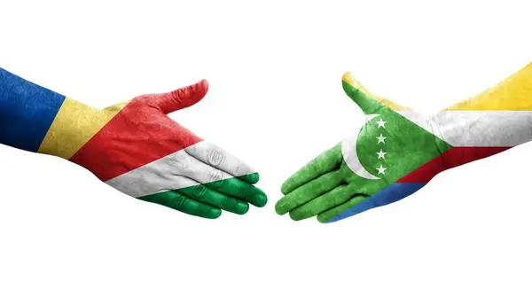 stock image Handshake between Comoros and Seychelles flags painted on hands, isolated transparent image.