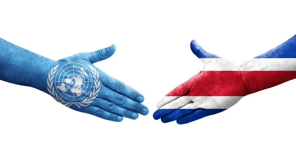 哥斯达黎加与手绘联合国旗帜 孤立透明的图像之间的握手 — 图库照片