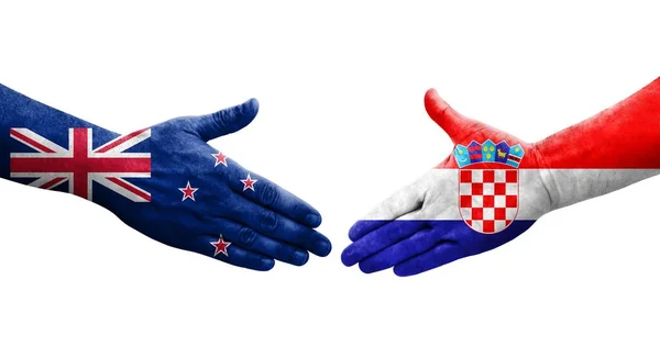 stock image Handshake between Croatia and New Zealand flags painted on hands, isolated transparent image.