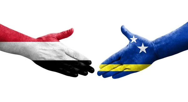 stock image Handshake between Curacao and Yemen flags painted on hands, isolated transparent image.