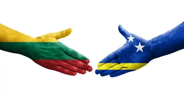 Stock image Handshake between Curacao and Lithuania flags painted on hands, isolated transparent image.