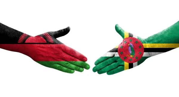 stock image Handshake between Dominica and Malawi flags painted on hands, isolated transparent image.