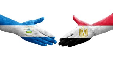 Mısır ve Nikaragua bayrakları arasındaki el sıkışma ellerinde resmedilmiş şeffaf görüntü.