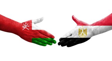 Mısır ve Umman bayrakları arasındaki el sıkışma ellerinde resmedilmiş şeffaf bir görüntü.