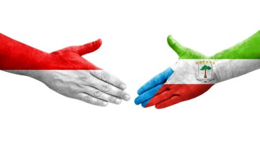 Ellerine boyanmış Ekvator Ginesi ve Endonezya bayrakları arasındaki el sıkışma, izole şeffaf görüntü.
