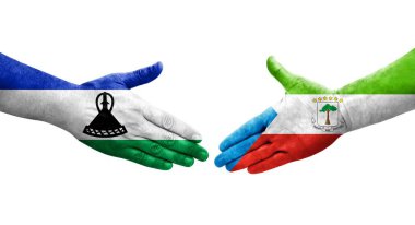 Ellere boyanmış Ekvator Ginesi ve Lesotho bayrakları arasındaki el sıkışma, izole şeffaf görüntü.